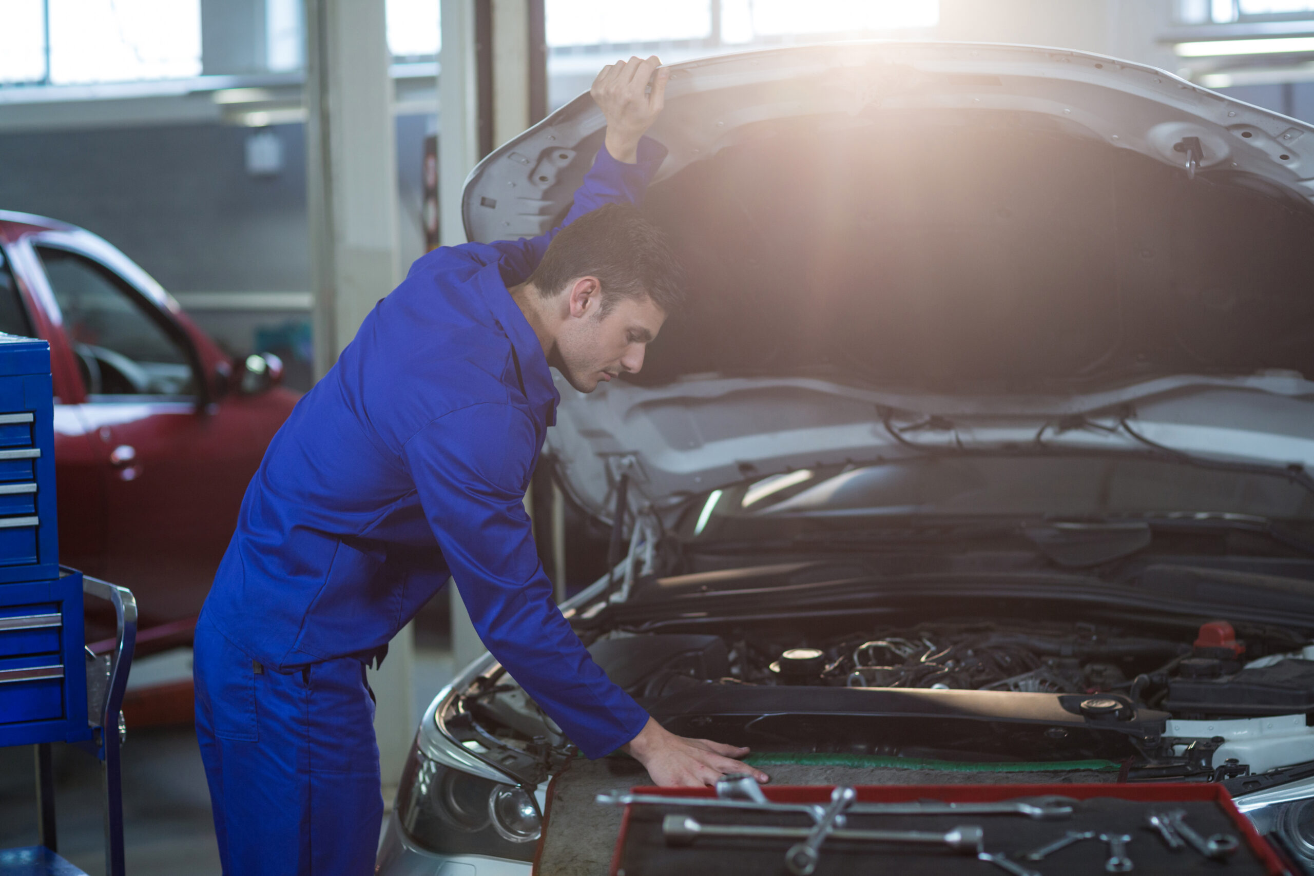 Mechanic servicing automobile car engine in repair garage